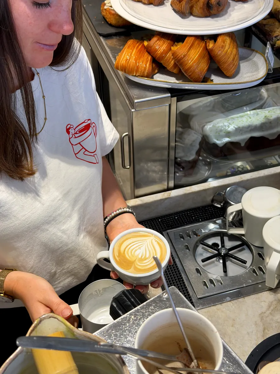 Une barista termine le latte art d’un café au comptoir